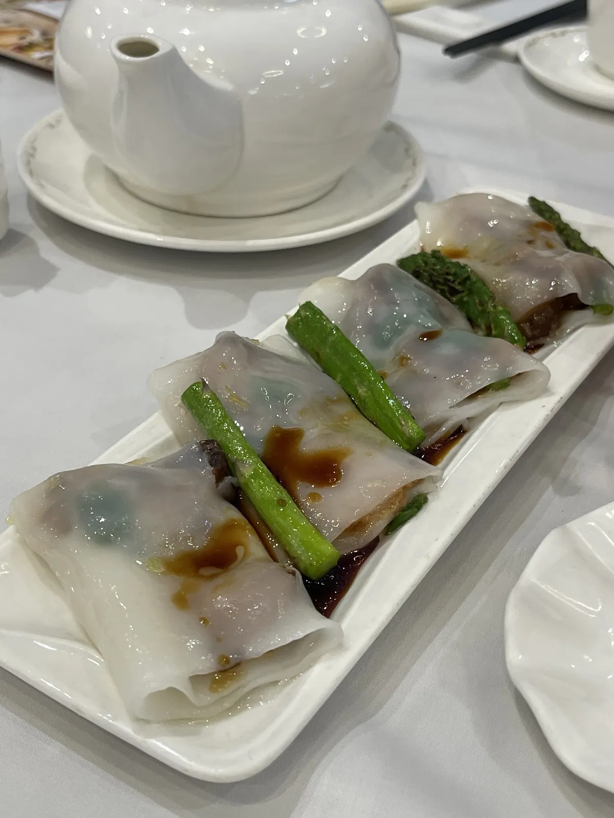 Plate of rice noodle rolls with green vegetables